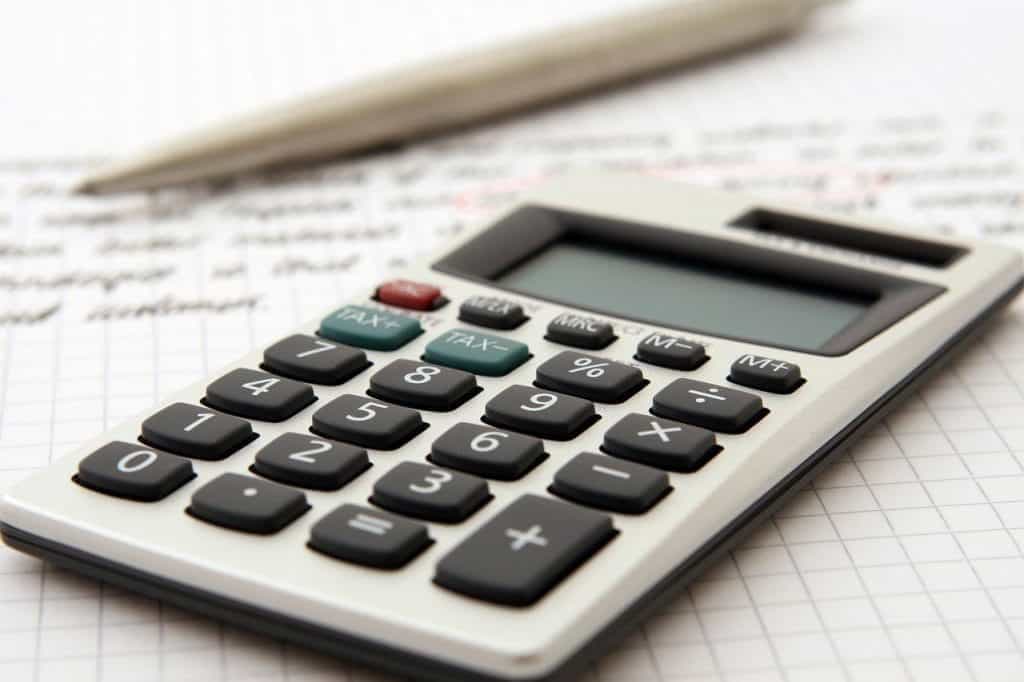 A calculator and pen on a sheet of paper.