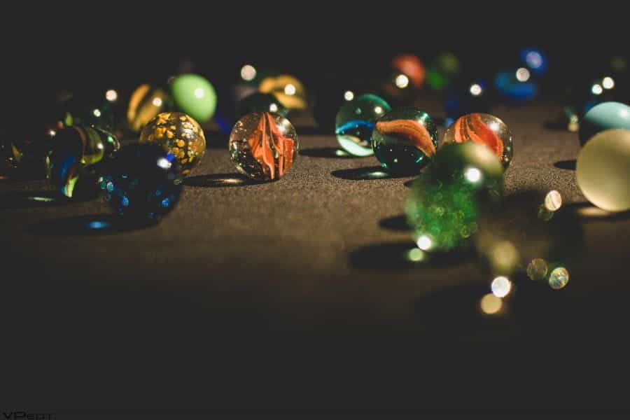 Colorful glass marbles against a dark background.