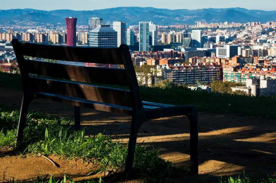 An empty bench overlooks Barcelona’s skyline.