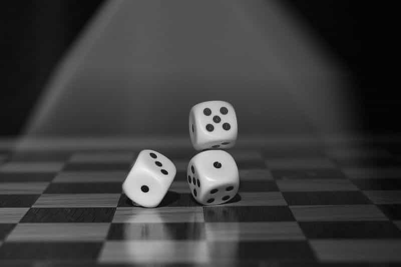 Three die on a checkered board as part of a board game.