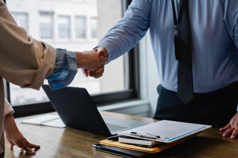 Two business people shaking hands in an office.