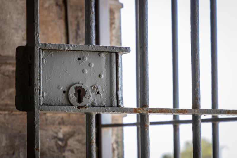 A closeup of a gray lock on a prison cell door.