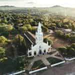 A church building surrounded by green trees in Paraguay.