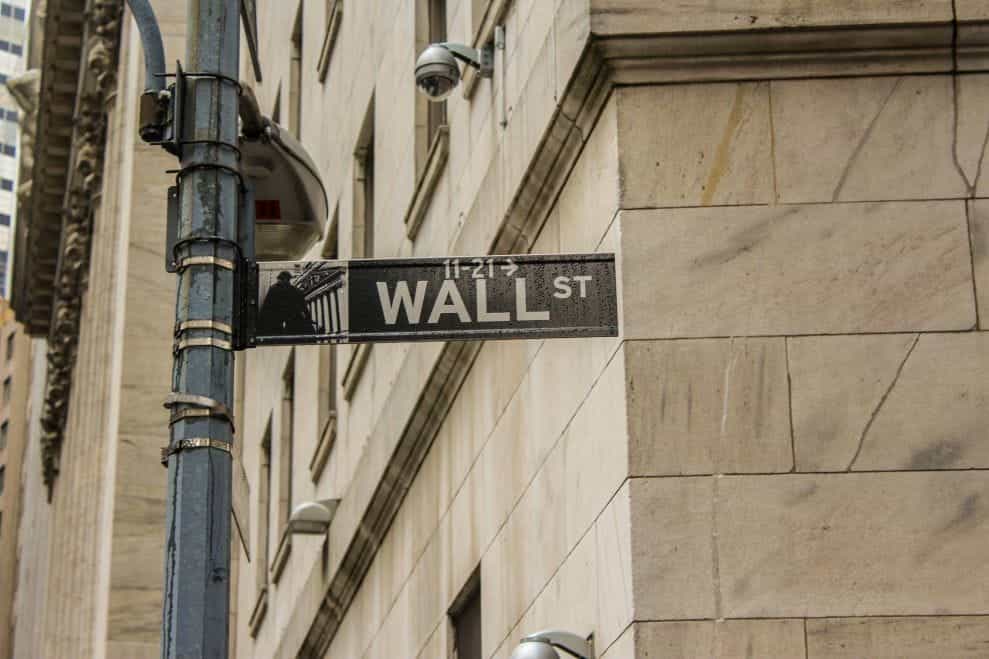 A street sign pointing towards Wall Street.