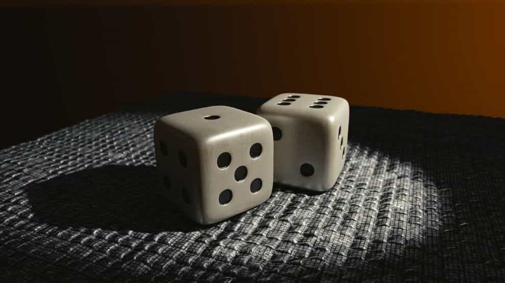 A pair of six-faced die resting on a table with a bright spotlight shining on them.