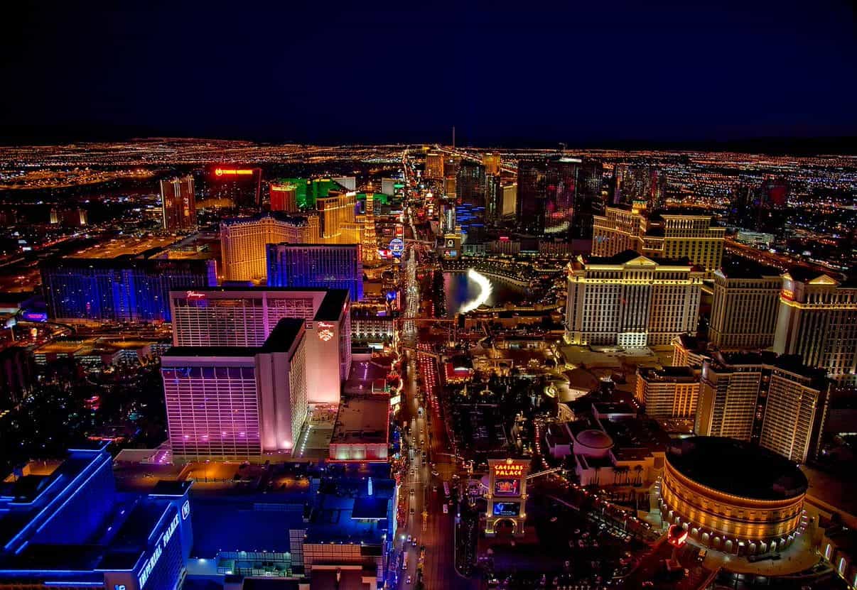 The “strip” in downtown Las Vegas, Nevada, showcasing a diverse series of world famous casinos, hotels, restaurants, storefronts, and the iconic replica Eiffel Tower in the middle of the long avenue.