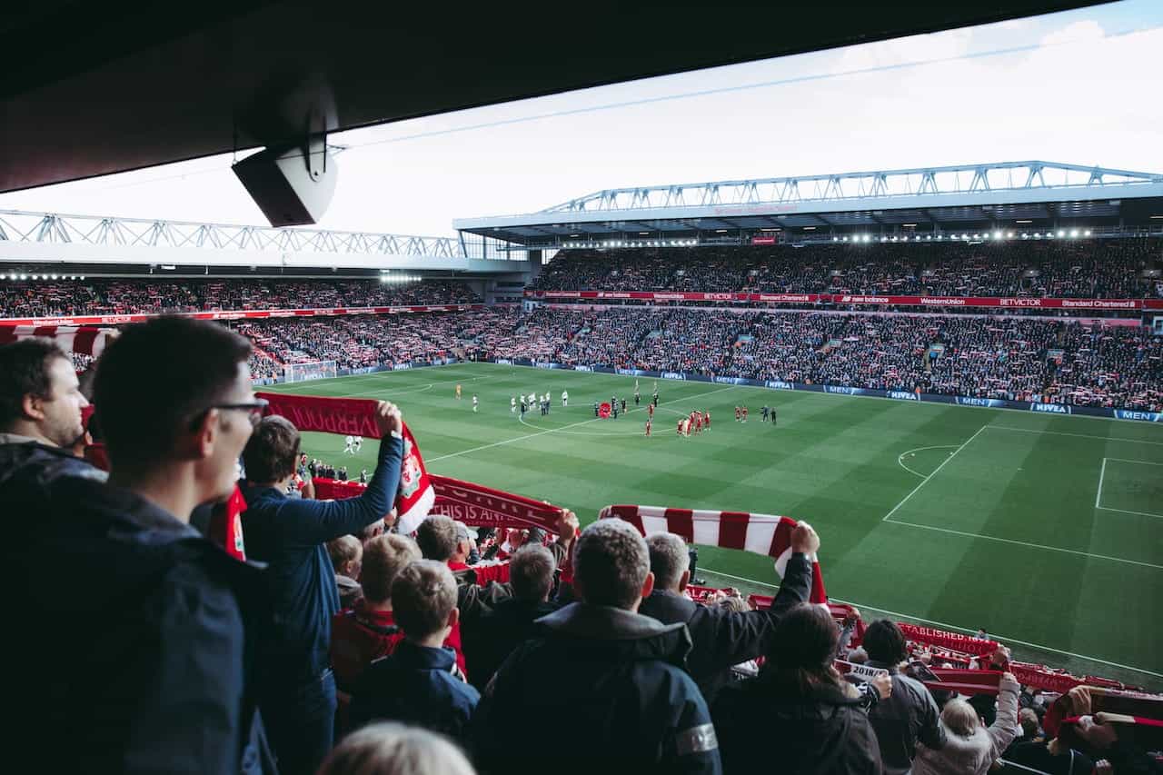 Fans watching a football match in a stadium.