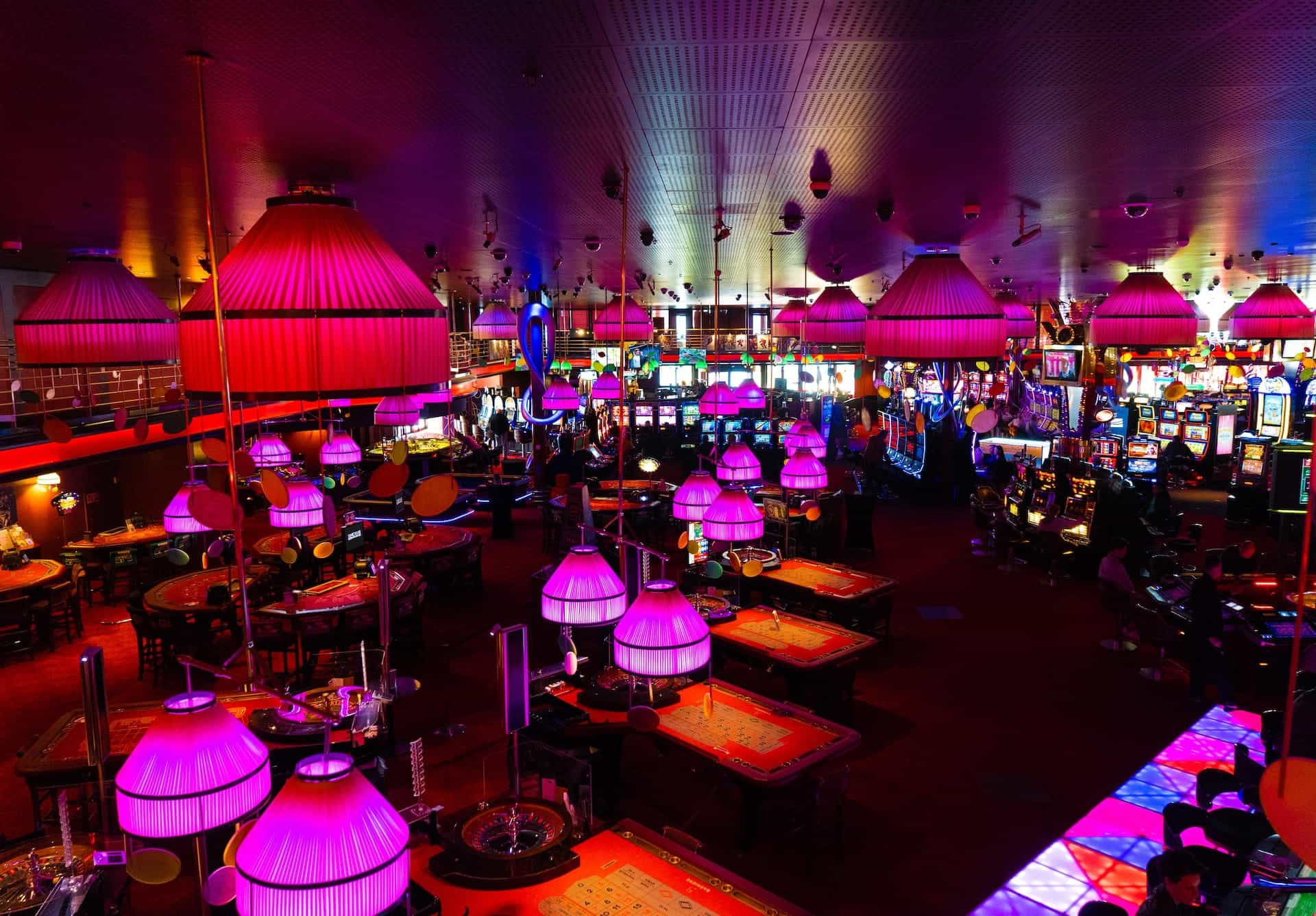 A dimly lit casino floor in Switzerland, with several gaming tables and machines.
