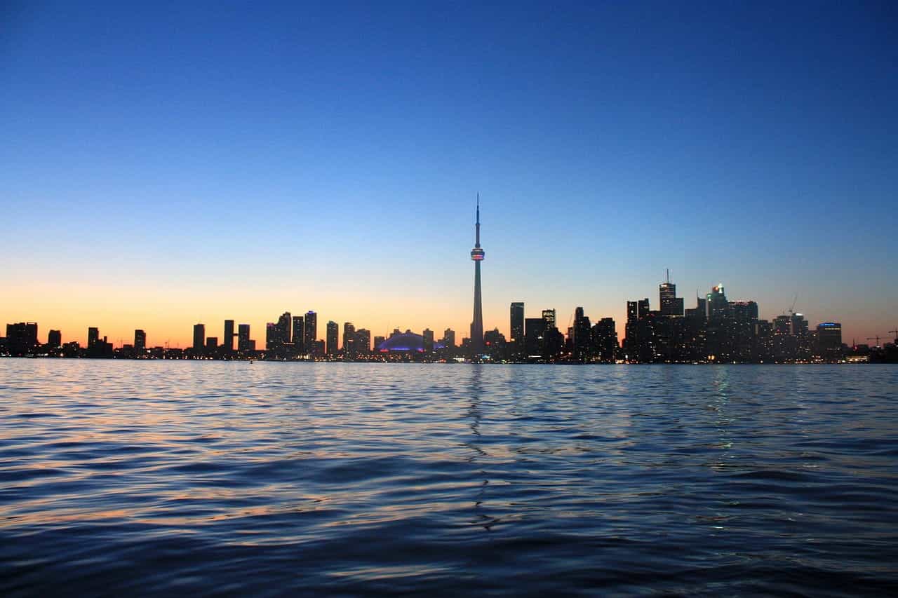 The skyline of downtown Toronto, Ontario off in the far distance as seen from the waters of Lake Ontario which stretch out in front of it, with the world famous CN Tower in the middle.