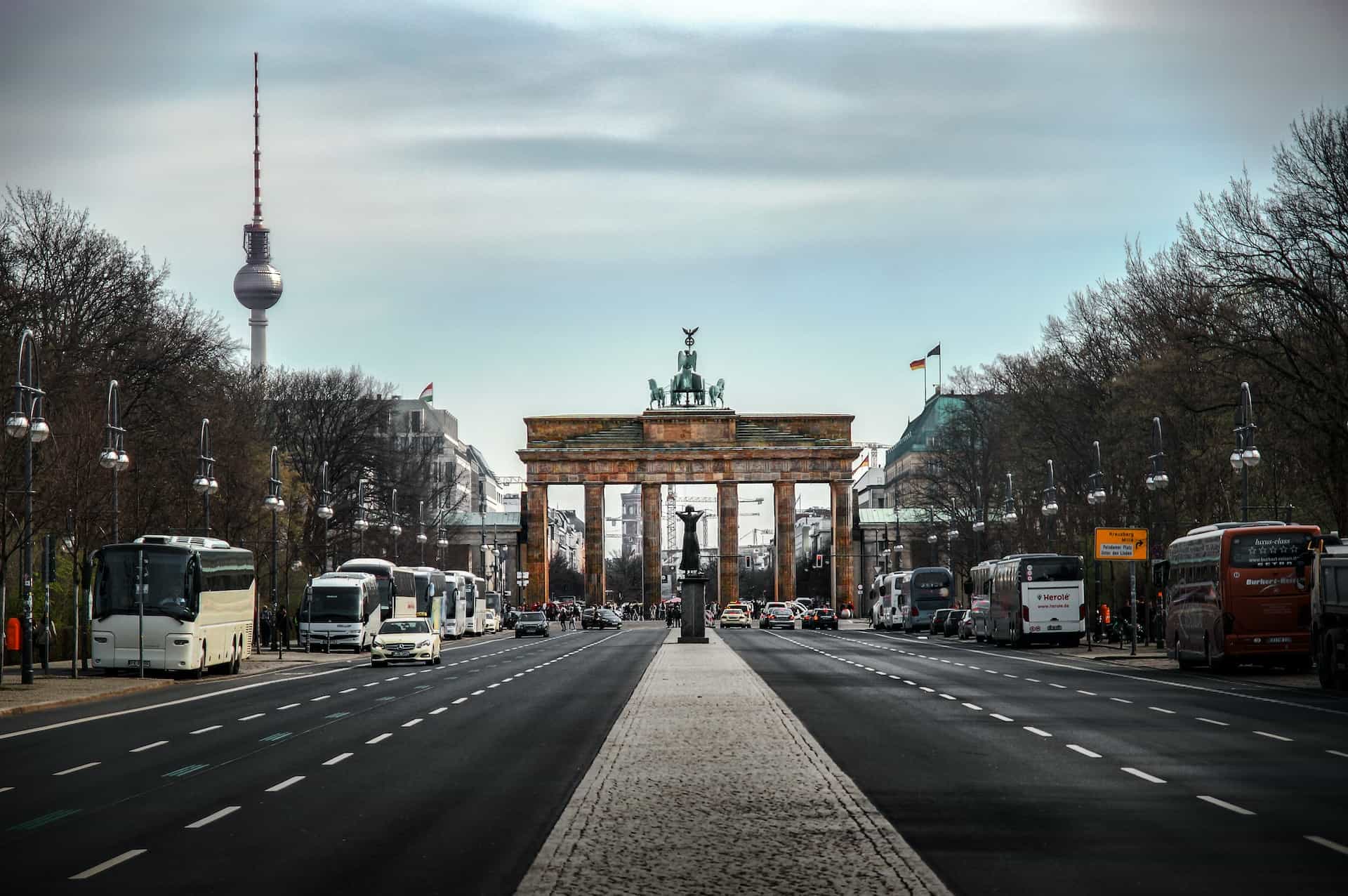 A divided two-way road with a gateway and vehicles on it.